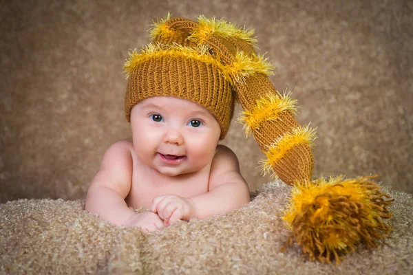 新生儿在针织的冬帽米色背景上. — 图库照片