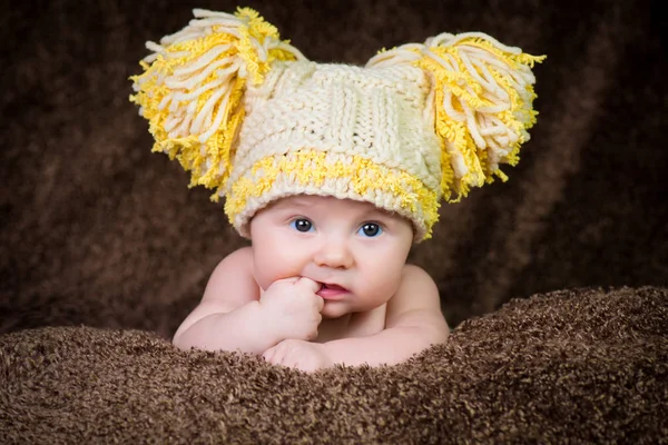 Nouveau-né en bonnet d'hiver tricoté sur fond beige . — Photo