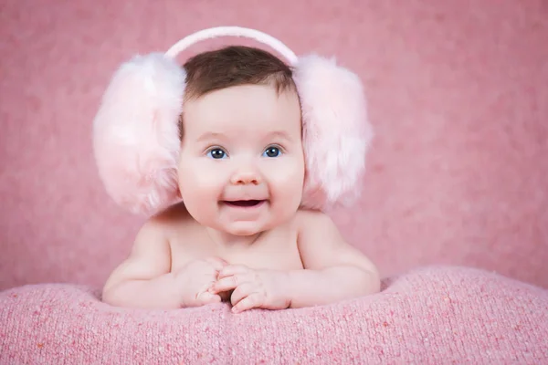 Krásná holčička v růžové teplé sluchátka — Stock fotografie