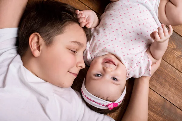 Brother hugging his newborn sister. View from above — Stock Photo, Image