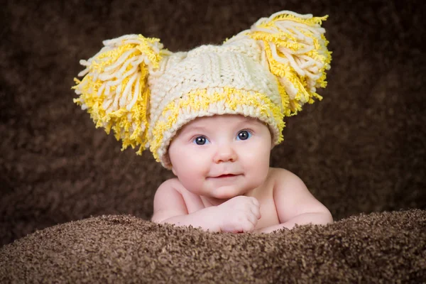 Recém-nascido em chapéu de inverno de malha em um fundo bege . — Fotografia de Stock