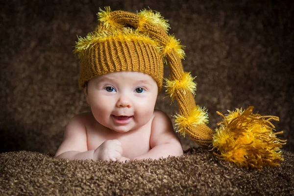 Nouveau-né en bonnet d'hiver tricoté sur fond beige . — Photo