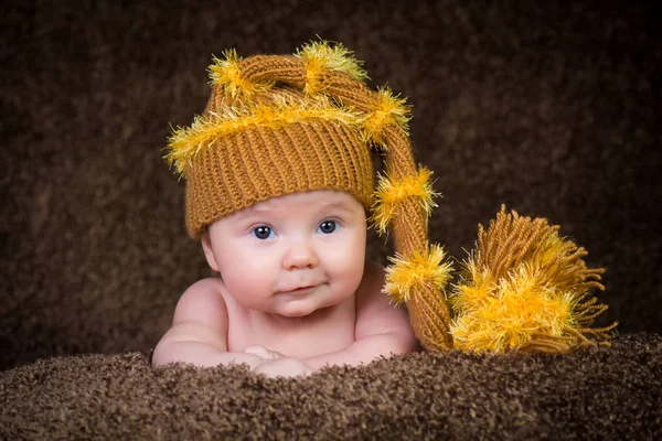 Nouveau-né en bonnet d'hiver tricoté sur fond beige . — Photo