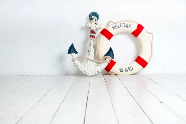 Anchor and life buoy on a white wooden floor — Stock Photo, Image