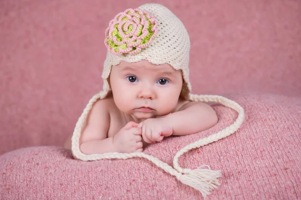 Bir çiçek ile sıcak örgü şapkalı yeni doğan kız — Stok fotoğraf