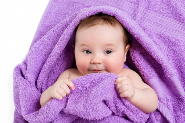 Bebê recém-nascido deitado e sorrindo em uma toalha roxa — Fotografia de Stock