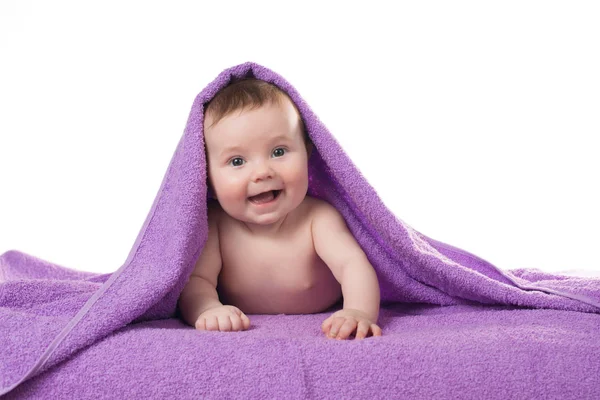 Pasgeboren baby liggend en lachend in een paarse handdoek — Stockfoto