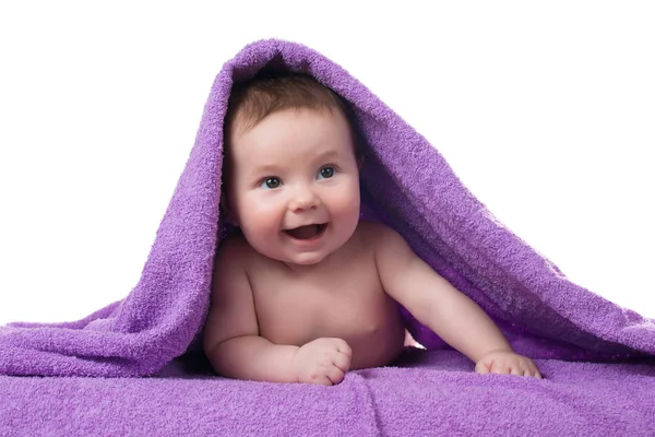 Neonato sdraiato e sorridente in un asciugamano viola — Foto Stock