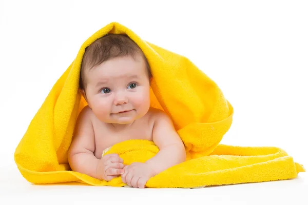 Newborn baby lying down and smiling in a yellow towel — Stock Photo, Image
