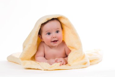 Aşağı uzanmış ve sarı bir havlu ile gülümseyen yeni doğan bebek