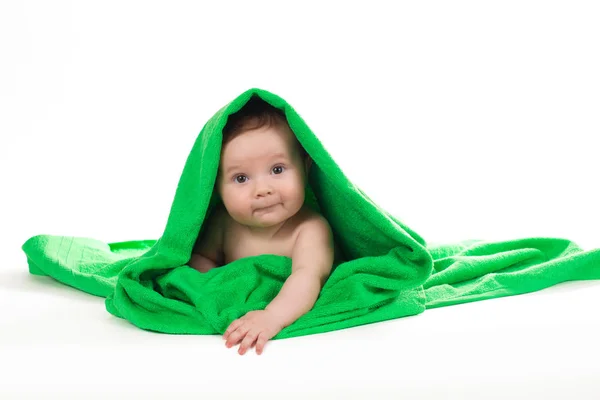 Pasgeboren baby liggend en lachend in een groene handdoek. — Stockfoto