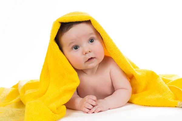 Newborn baby lying down and smiling in a yellow towel — Stock Photo, Image