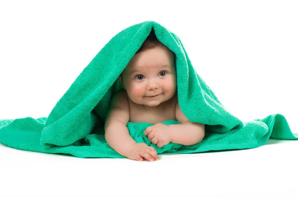 Bayi yang baru lahir berbaring dan tersenyum dengan handuk hijau . — Stok Foto