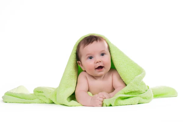 Newborn baby lying down and smiling in a green towel. — Stock Photo, Image