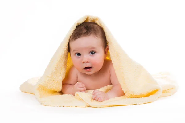 Neonato sdraiato e sorridente in un asciugamano giallo — Foto Stock