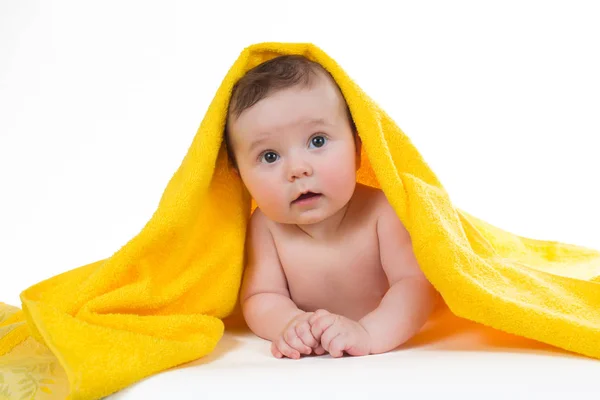 Newborn baby lying down and smiling in a yellow towel — Stock Photo, Image