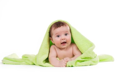 Aşağı uzanmış ve yeşil bir havlu ile gülümseyen yeni doğan bebek.