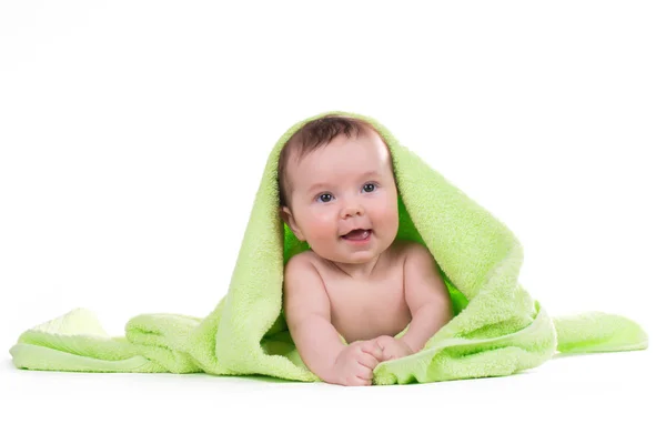 Newborn baby lying down and smiling in a green towel. — Stock Photo, Image