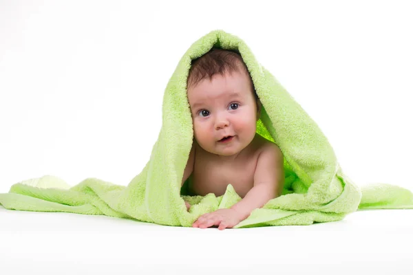 Pasgeboren baby liggend en lachend in een groene handdoek. — Stockfoto