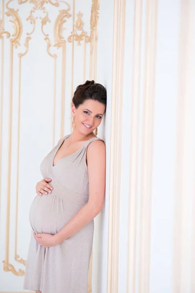 Portrait of a beautiful pregnant woman hugging her belly. — Stock Photo, Image