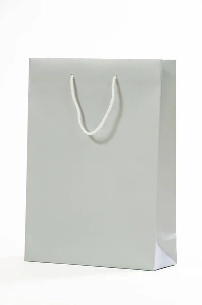 Серый бумажный пакет на белом фоне . — стоковое фото