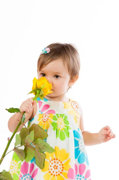 Piccola ragazza carina che profuma di rosa gialla, regalo romantico — Foto Stock