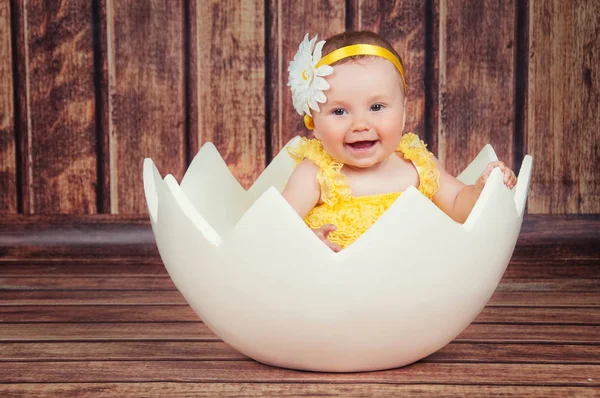 Cute little girl in the egg basket. — Stock Photo, Image