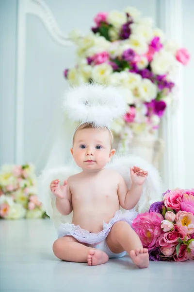 Little angel smiling and happy sitting on the background of flowers and harp — Stock Photo, Image