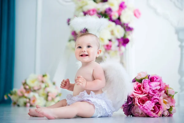 Маленький ангел посміхається і щасливий сидить на тлі квітів і арфи — стокове фото