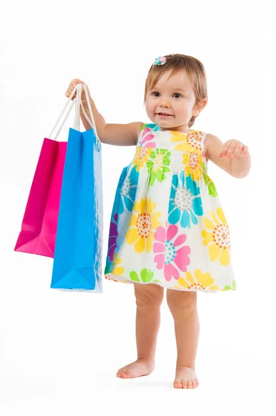 Bambina in piedi con sacchetti di carta colorati isolati su sfondo bianco . — Foto Stock