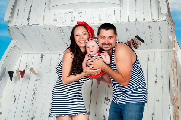 Happy family. Mother, father and little daughter in a nautical style. — Stock Photo, Image