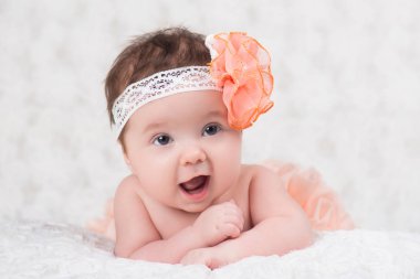 Newborn girl portrait with knitted bandage in the form of a flower. clipart