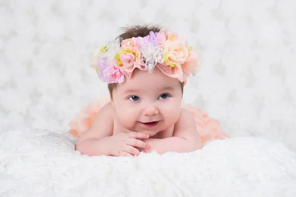 Newborn girl portrait with knitted bandage in the form of a flower. — Stock Photo, Image