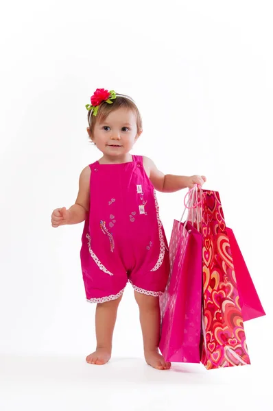 Niña de pie con coloridas bolsas de papel aisladas sobre fondo blanco . — Foto de Stock