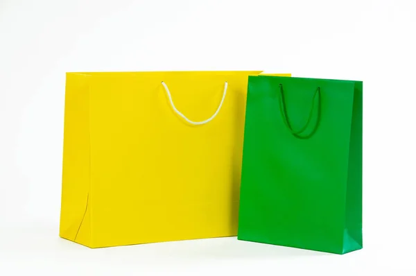 Saco de papel amarelo e verde sobre um fundo branco . — Fotografia de Stock