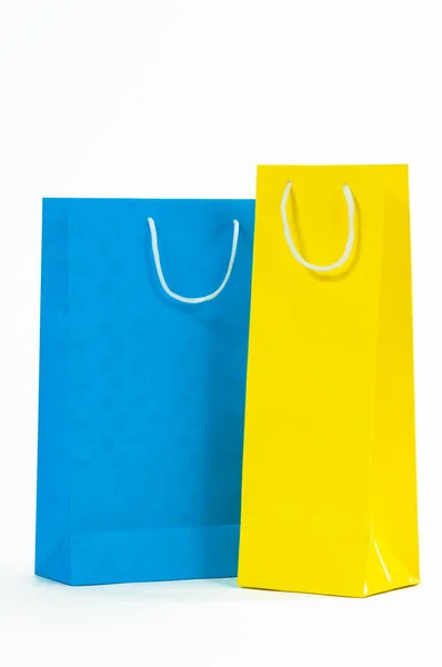 Bolso de papel amarillo y azul sobre fondo blanco . — Foto de Stock
