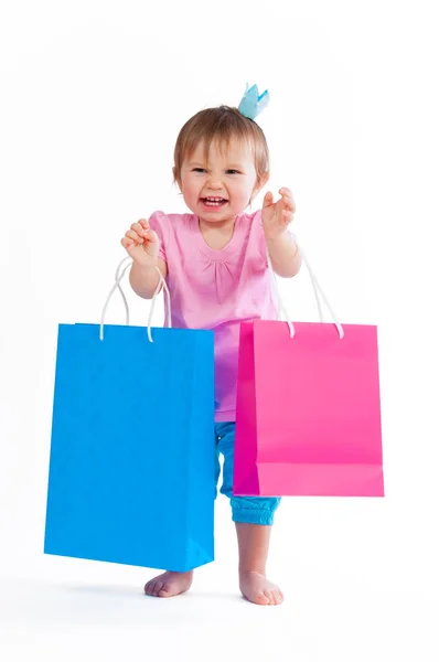 Chica dulce en diseño rosa y azul con bolsas de papel aisladas sobre fondo blanco . —  Fotos de Stock