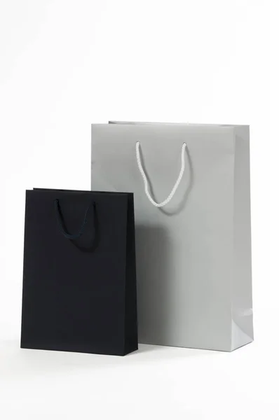 Серебряный и черный бумажный пакет на белом фоне — стоковое фото