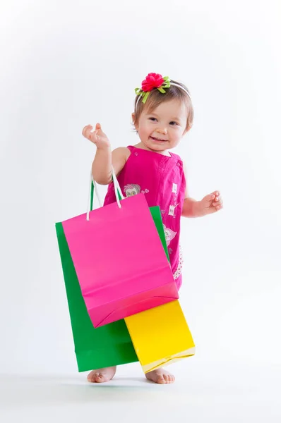 Chica dulce en diseño rosa y azul con bolsas de papel aisladas sobre fondo blanco . —  Fotos de Stock