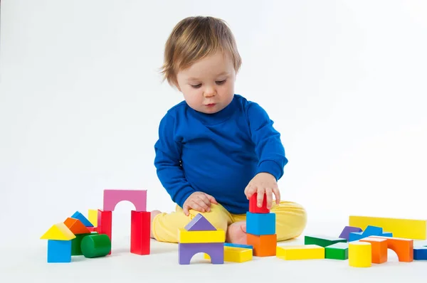Kleines Kind spielt mit Würfeln auf weißem Hintergrund — Stockfoto