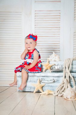 Küçük bir seyahat bavul Kırmızı elbiseli oturur.