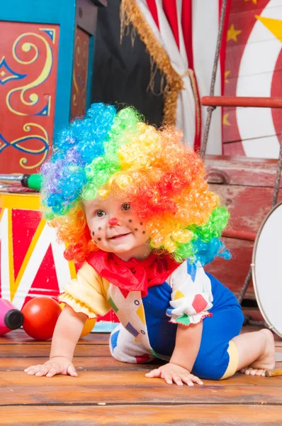 Lilla baby clown med röd näsa flerfärgad peruk in med bollar — Stockfoto