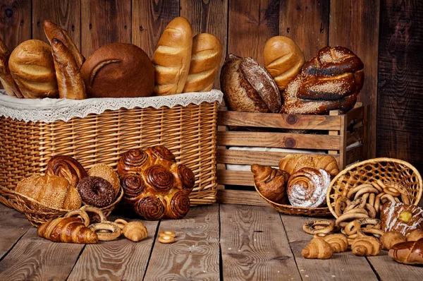 Composición con pan y rollos en canasta de mimbre . —  Fotos de Stock