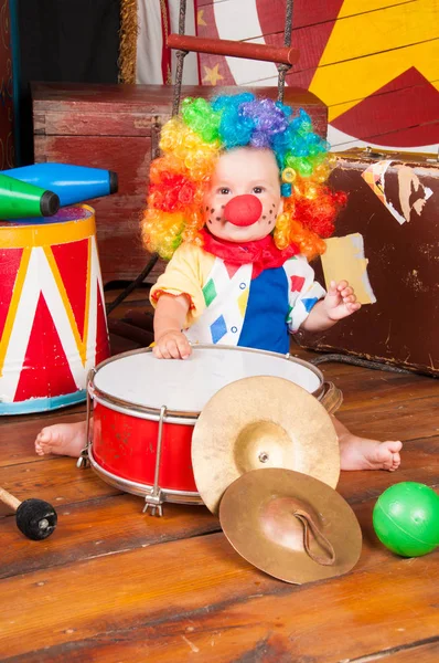 Lilla baby clown med röd näsa flerfärgad peruk in med bollar — Stockfoto