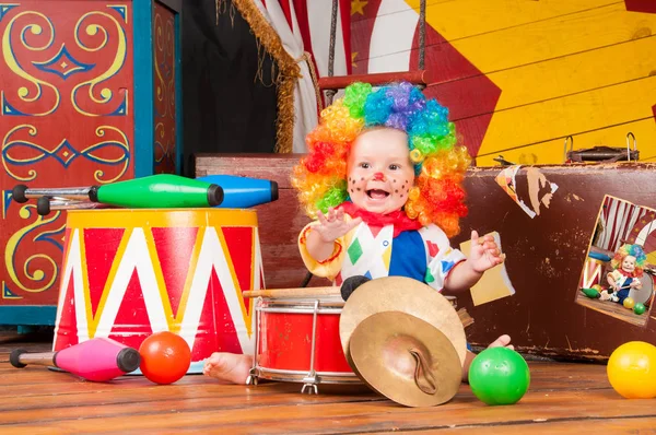 Pequeno palhaço bebê com nariz vermelho multi-colorido peruca com bolas — Fotografia de Stock
