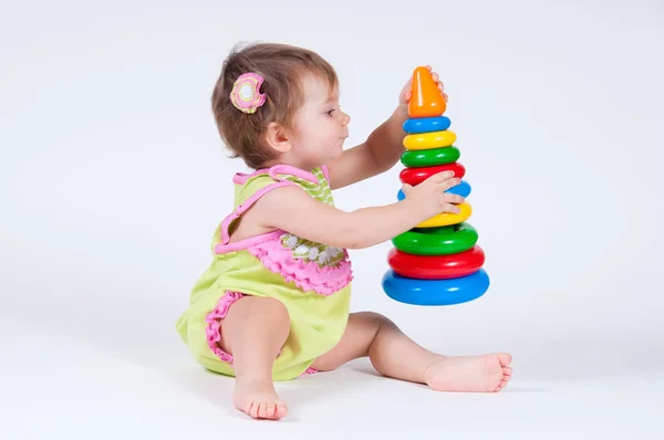 Linda niña jugando con una pirámide de juguetes — Foto de Stock