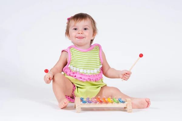 Menina com emoção jogando em um xilofone isolado no branco — Fotografia de Stock