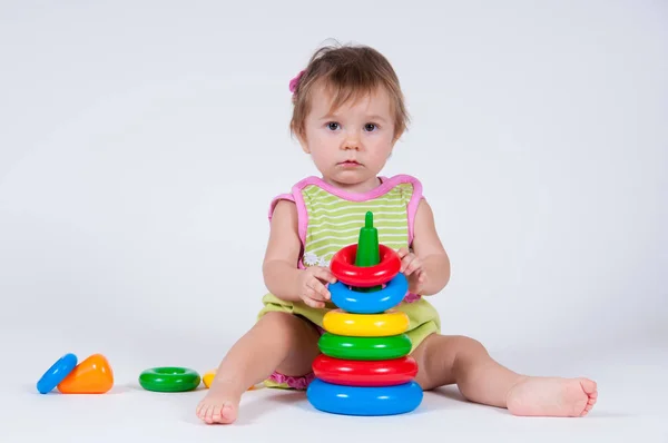 Niedliches kleines Mädchen spielt mit einer Spielzeugpyramide Stockbild