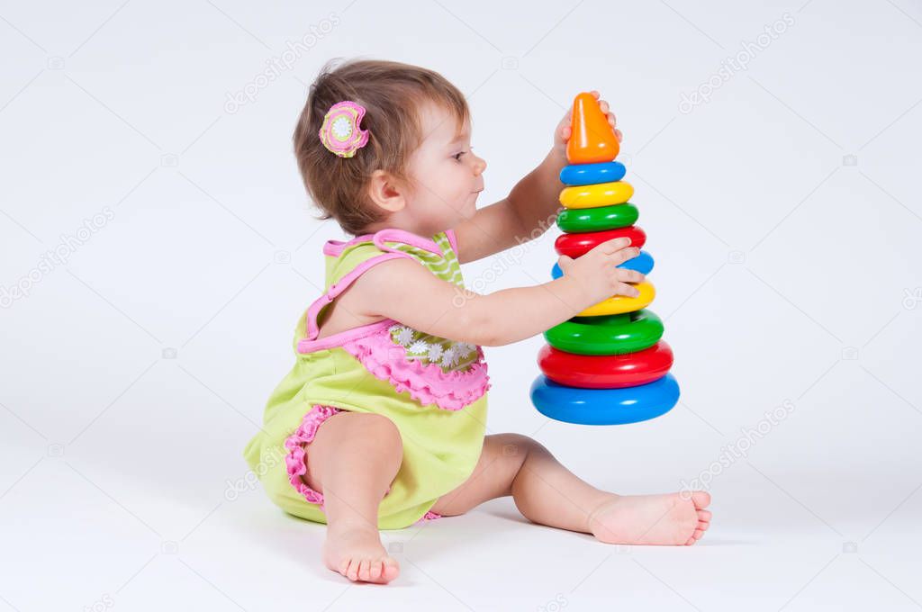 Cute little girl playing with a toy pyramid