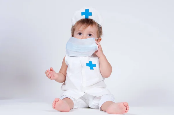 Bir hemşire oynayan kız çocuk içinde bir yüz maskesi